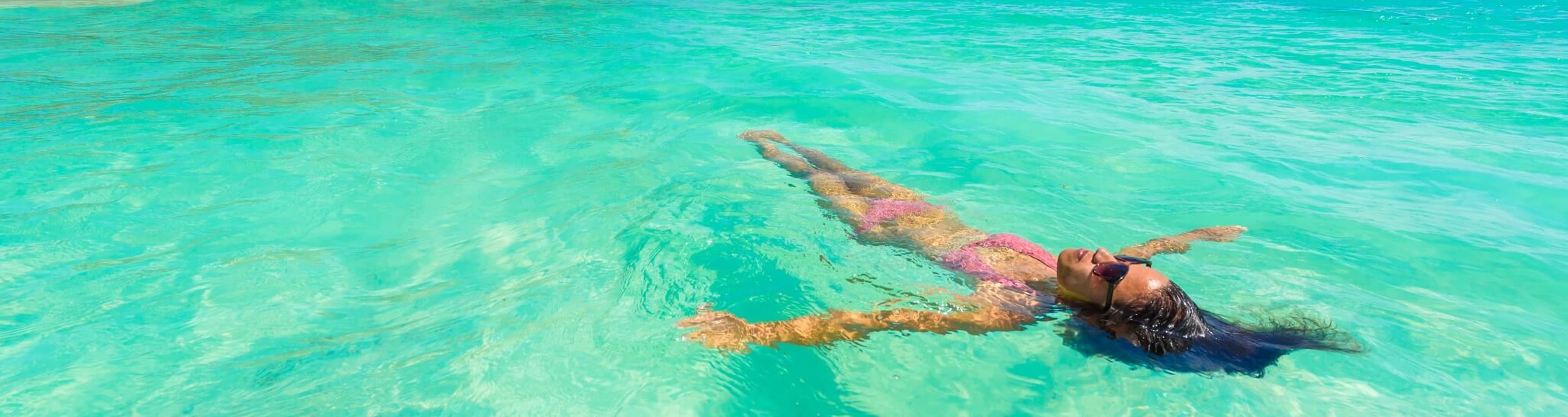 A woman floats in the shallows in Cancun