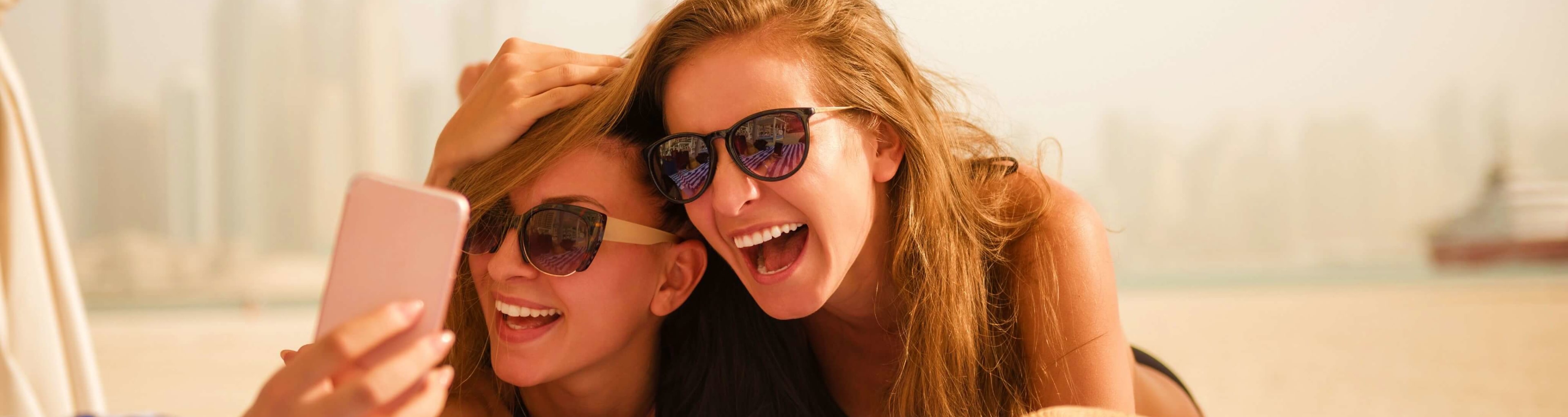 Two girls mess about on a Dubai beach