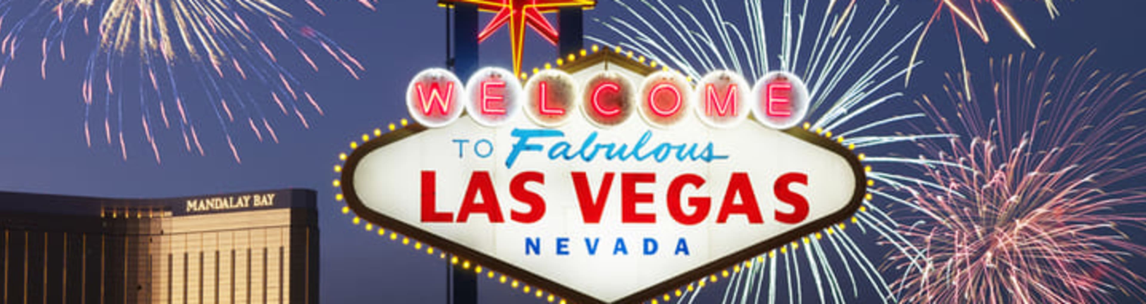 Fireworks exploding behind the neon-lit 'Welcome to Fabulous Las Vegas' road sign