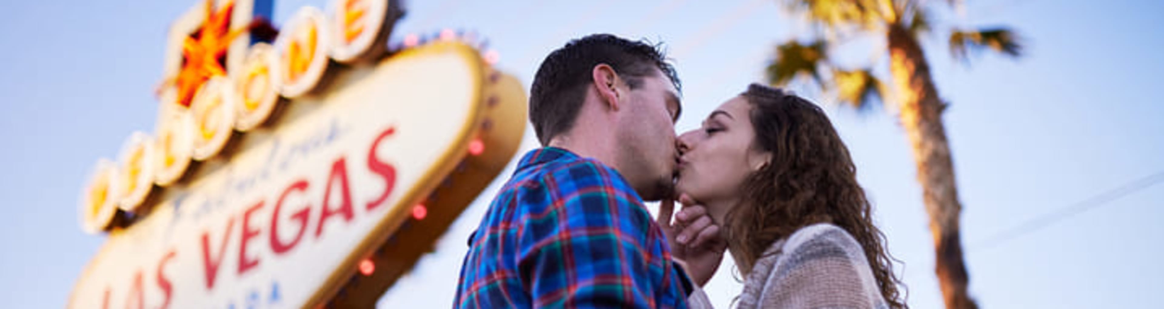 Couple kissing in front of the 'Welcome to Fabulous Las Vegas' sign