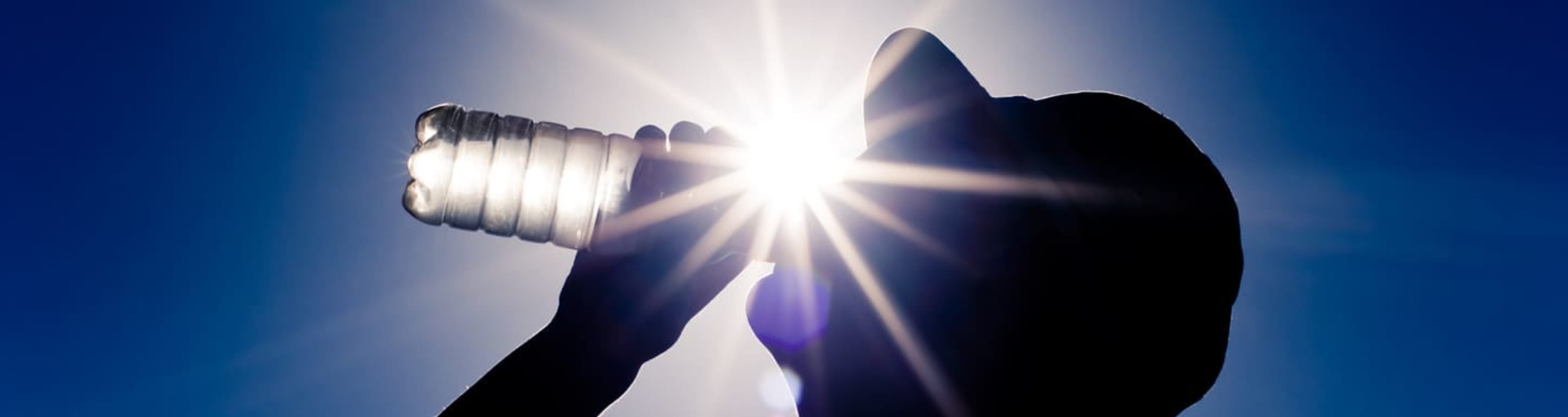 Silhouette of man drinking water on a hot day