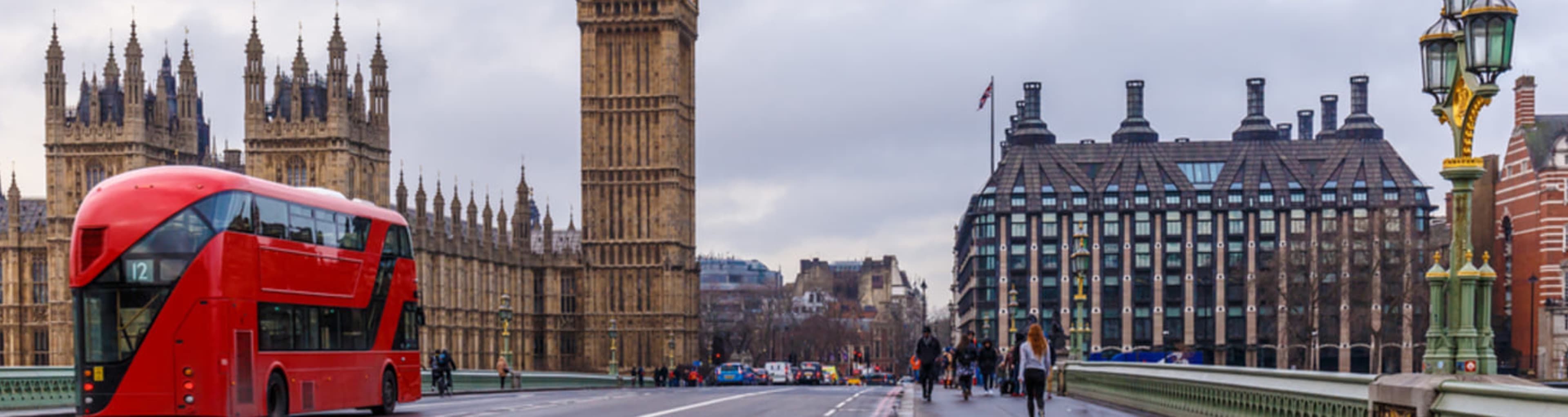 Double decker London bus crossing Westminster Bridge towards Big Ben.