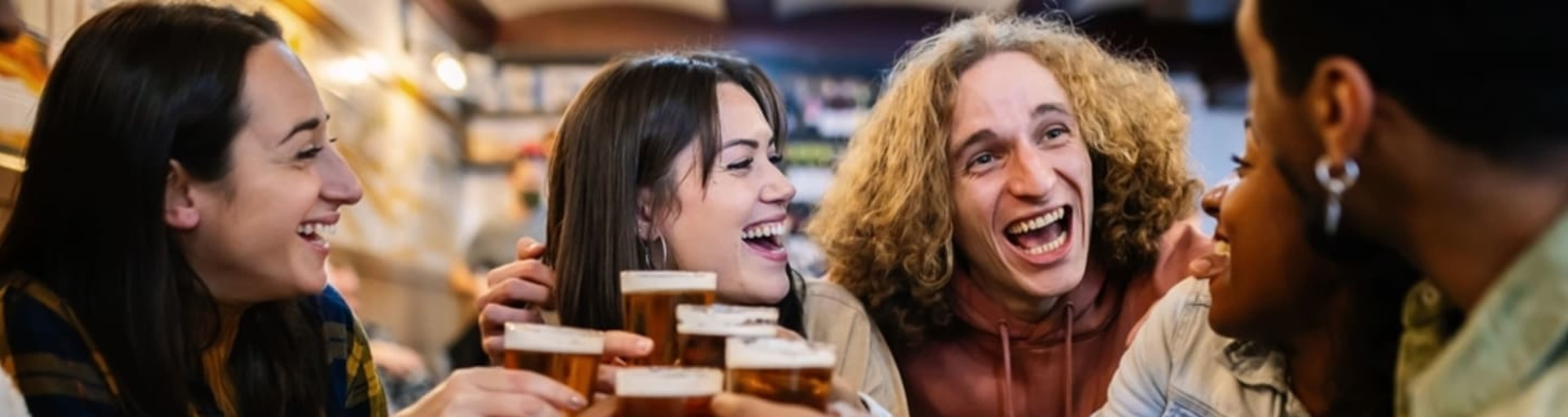 Group of friends drinking pints of beer in a London pub.