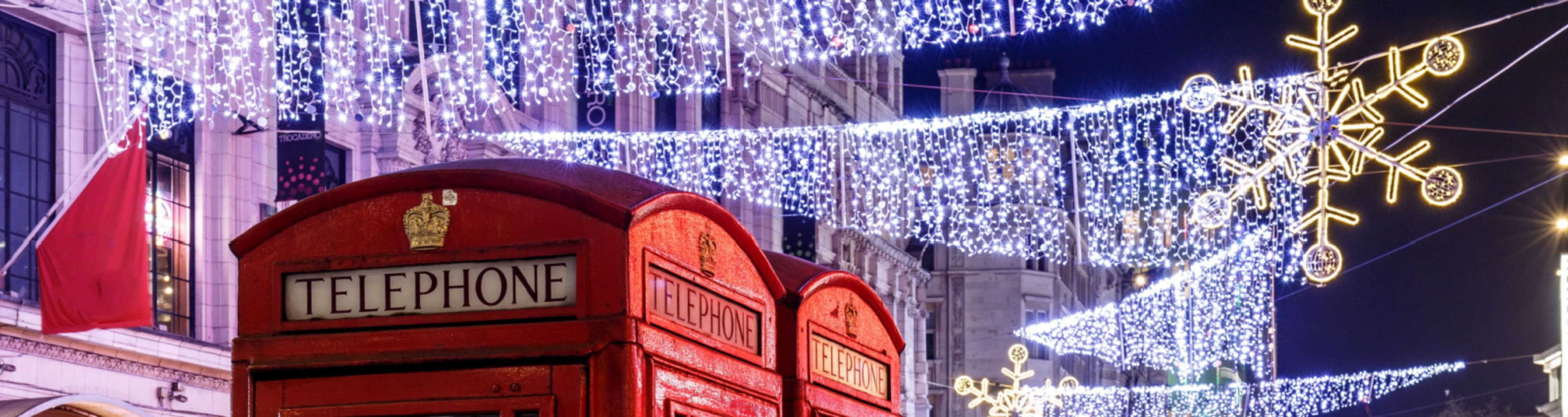 Busy street in London with two phone boxes and Christmas lights