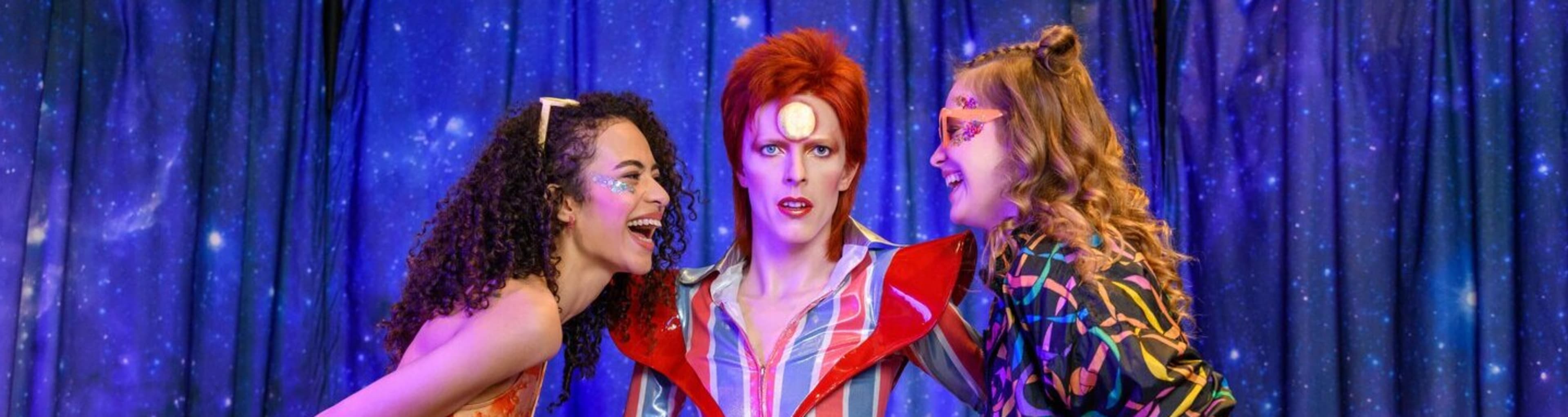 Chicas posando con la estatua de cera de David Bowie de Madame Tussauds Londres.