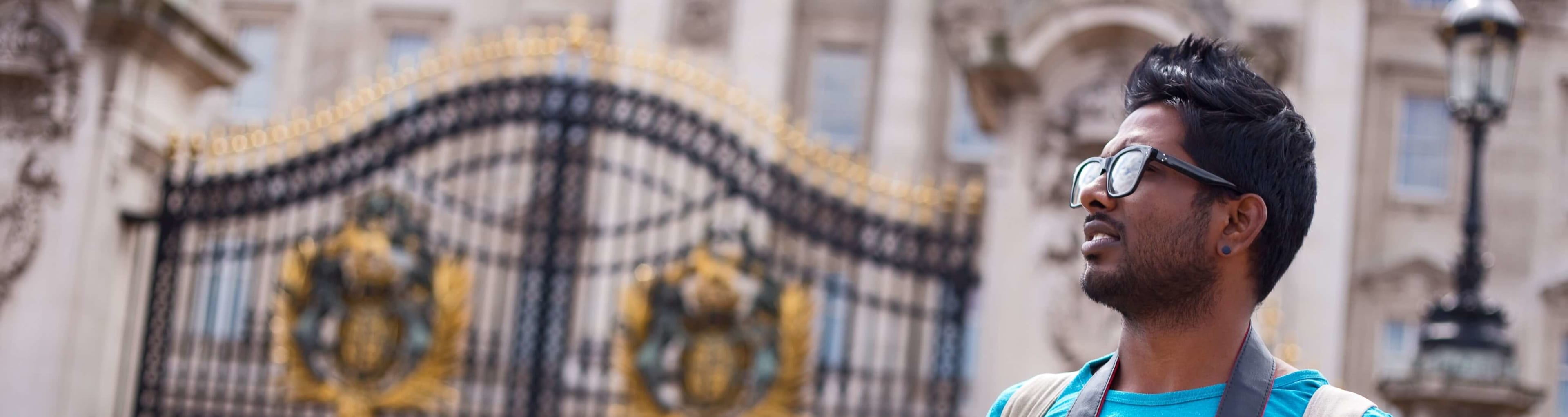 A tourist standing outside the gates of London's Buckingham Palace