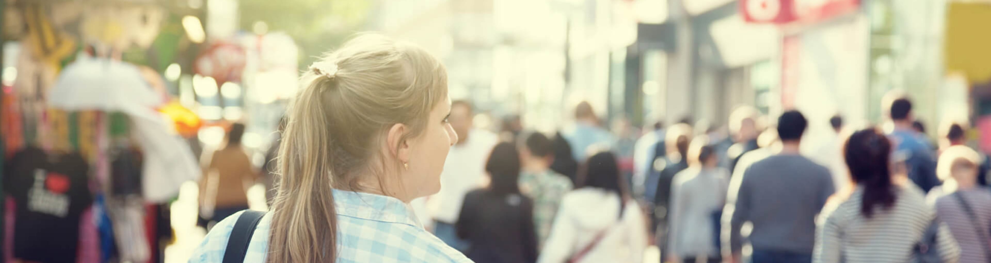 A woman walks alone through a busy London street