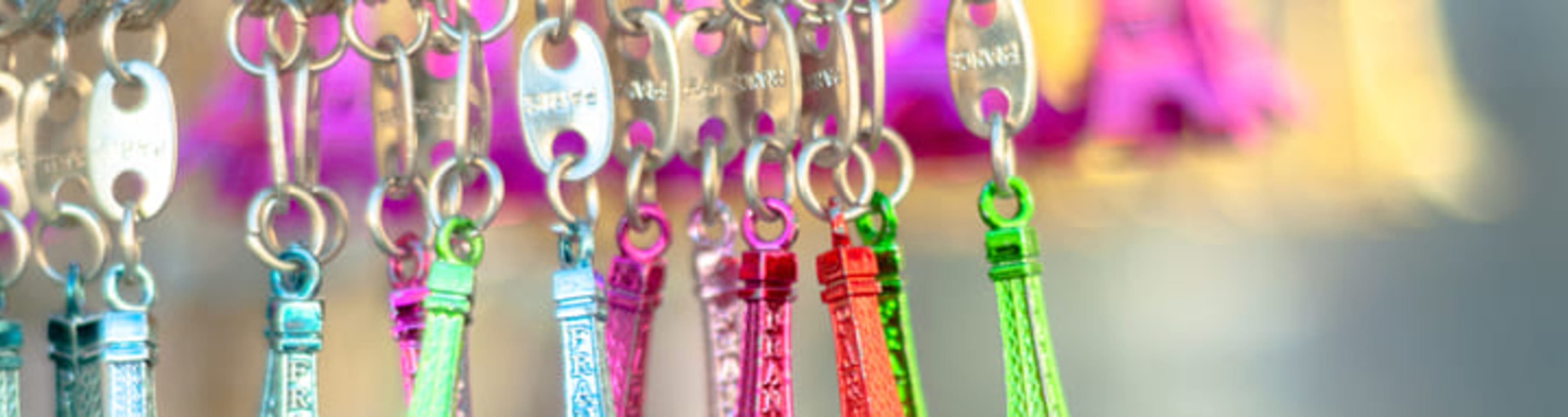 A row of colourful Eiffel Tower keyrings on display in a shop