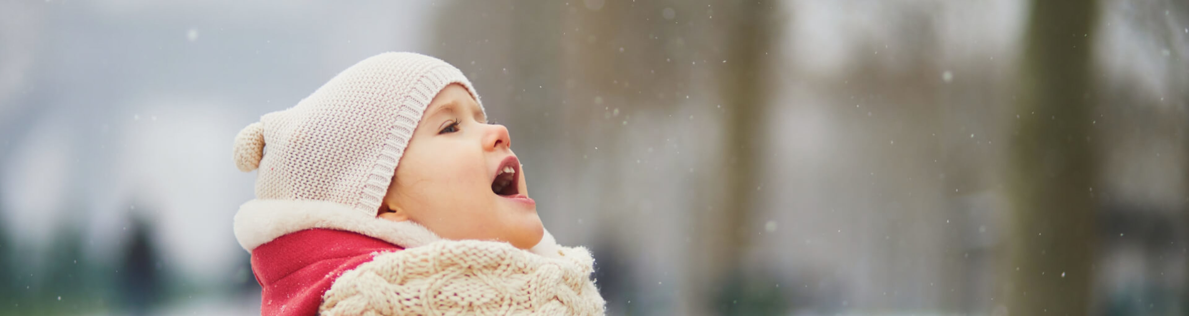 A toddler enjoys a snow shower in Paris in January