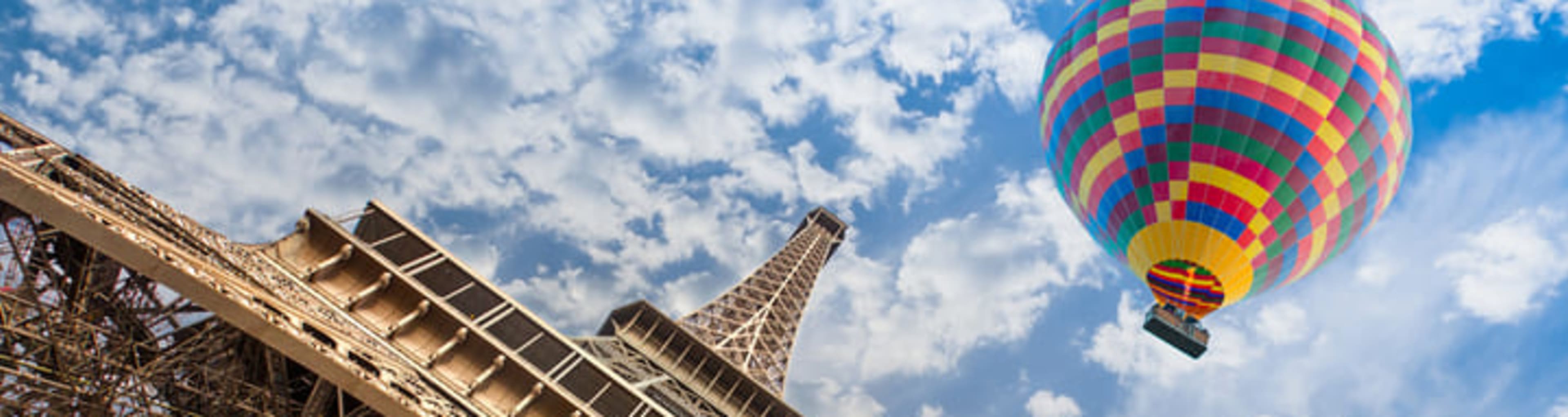 A hot-air balloon passes by the Eiffel Tower