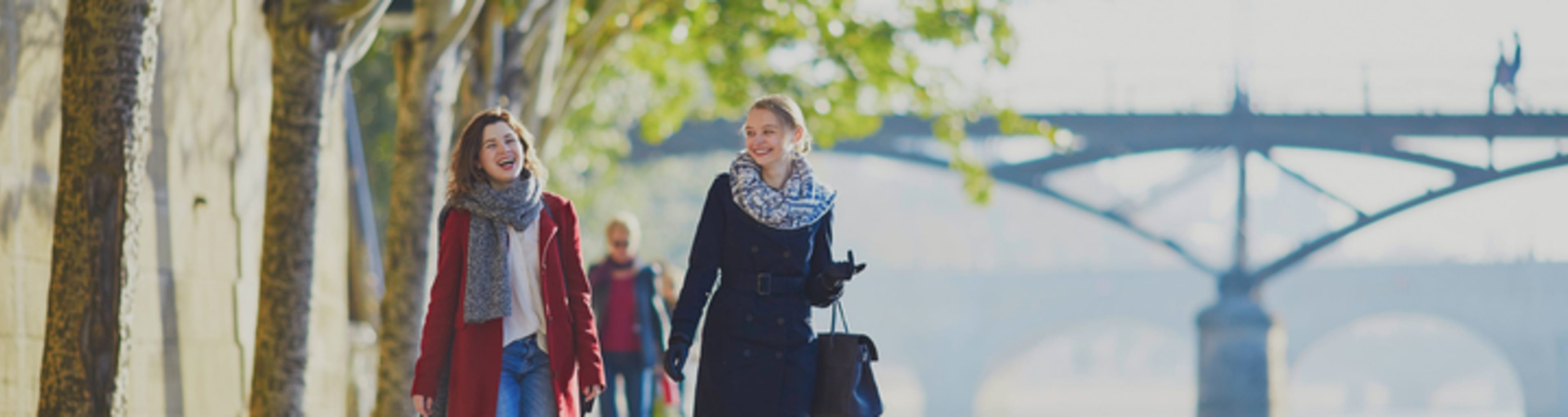 Two women walking along the Seine in Paris.