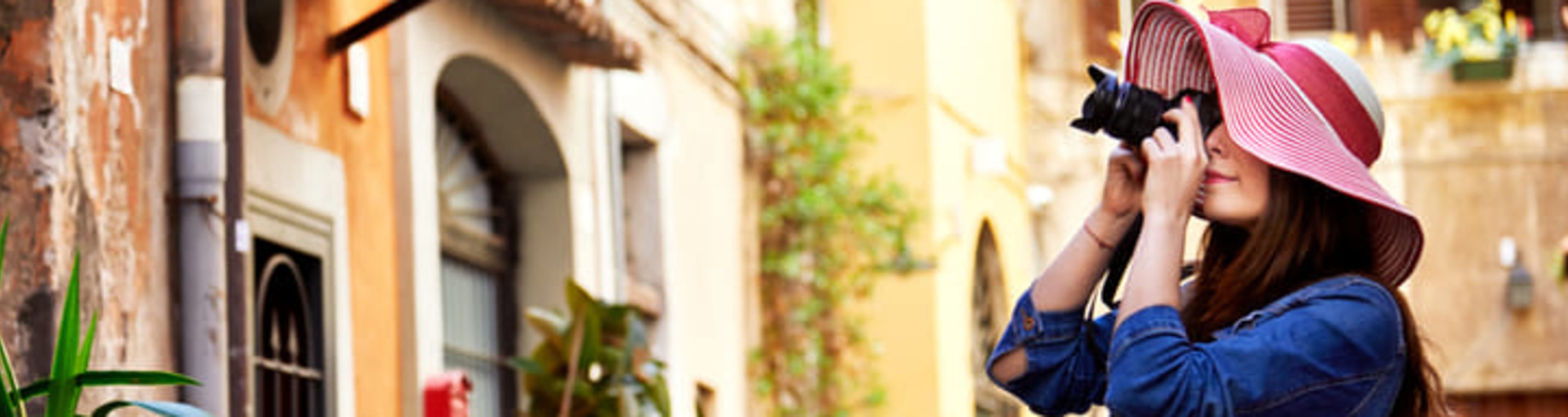 Woman taking photographs in a picturesque square in Trastevere, Rome