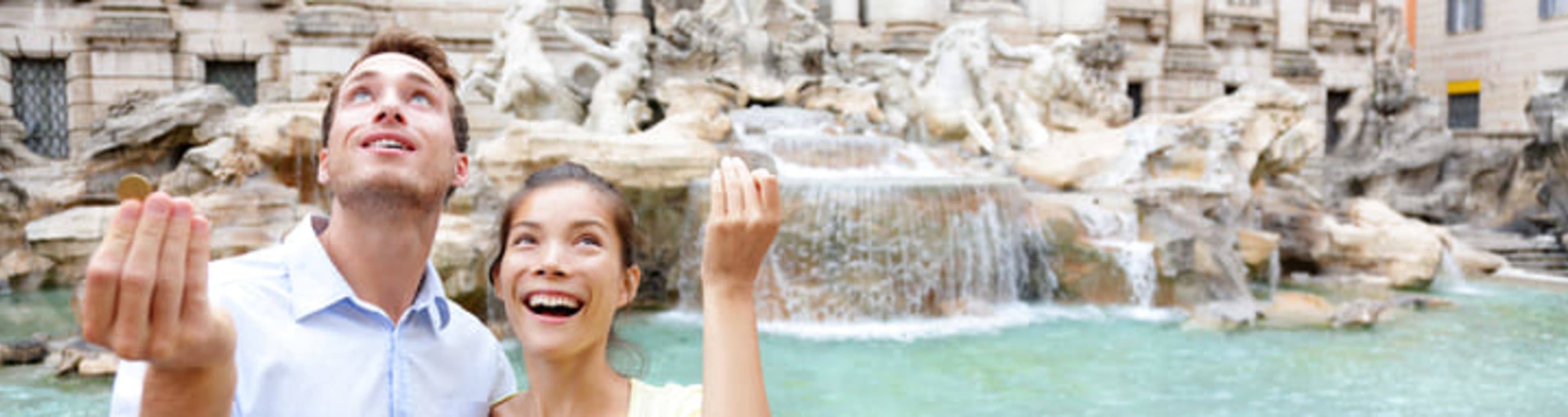 Couple throwing coins over their shoulders into the Trevi Fountain in Rome