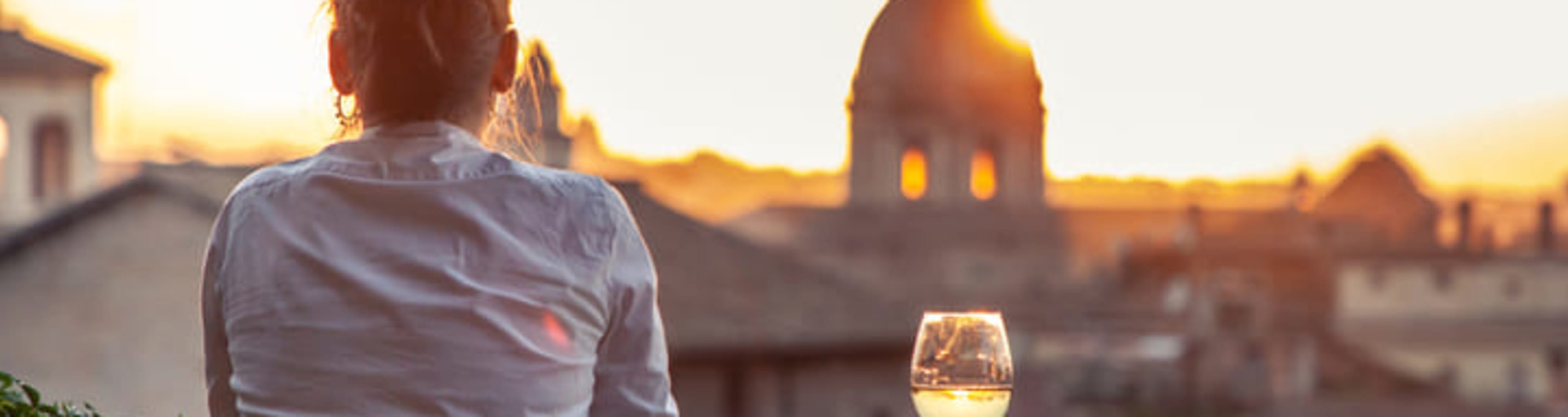 Woman enjoying a glass of wine at sunset in Rome