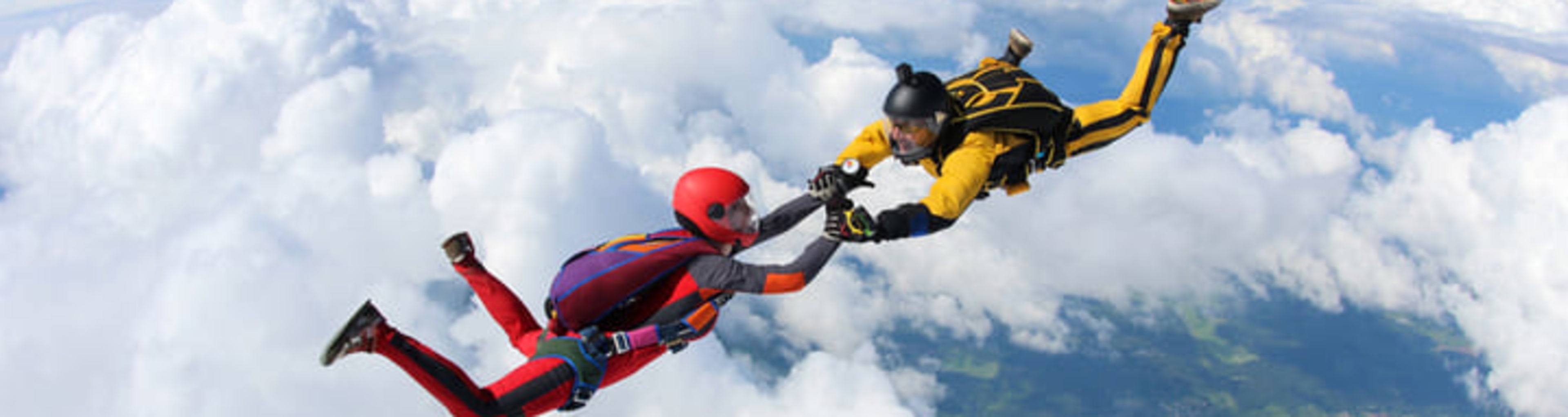 A pair of skydivers above the clouds