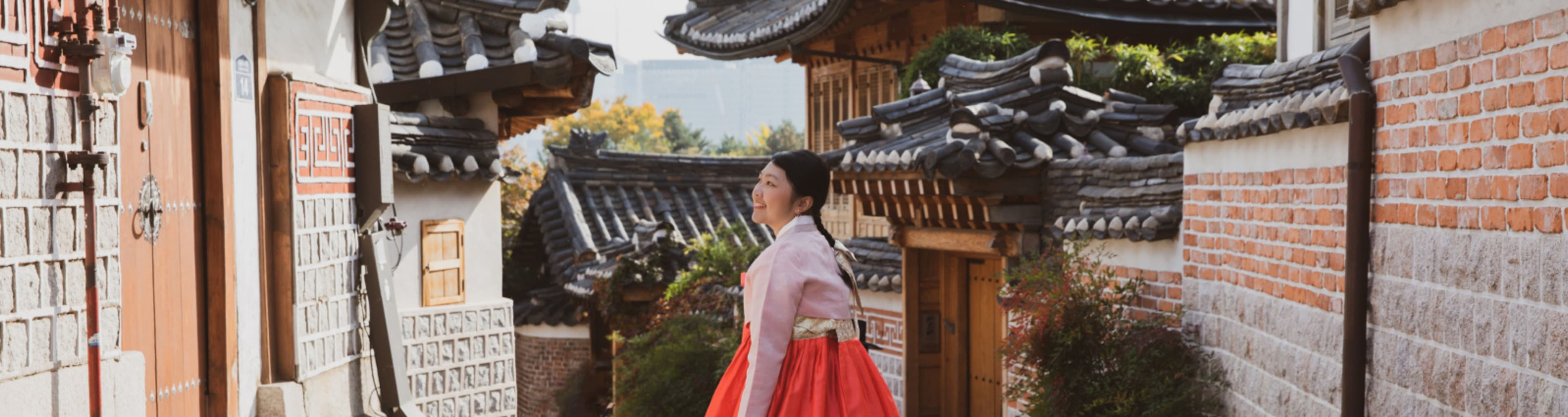 Woman in a hanbok exploring a traditional Korean village