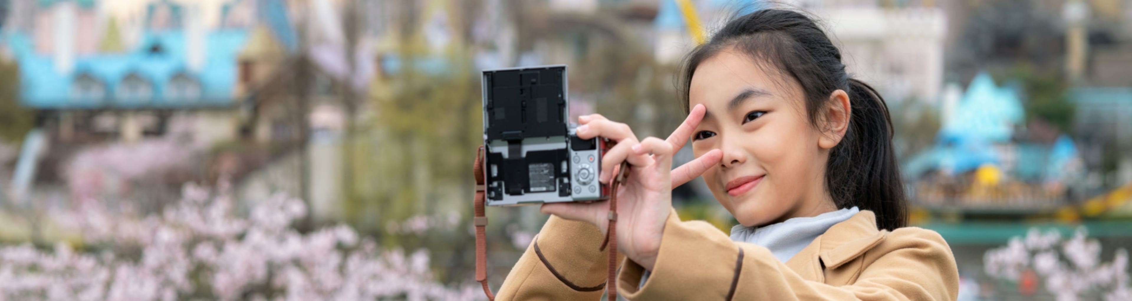 Girl takes a selfie in Seoul with cherry blossoms in the background