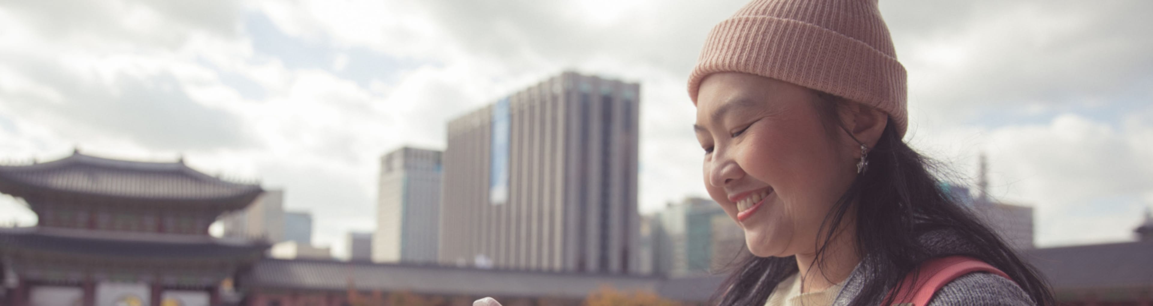 A woman near a palace in Seoul checks her cell phone