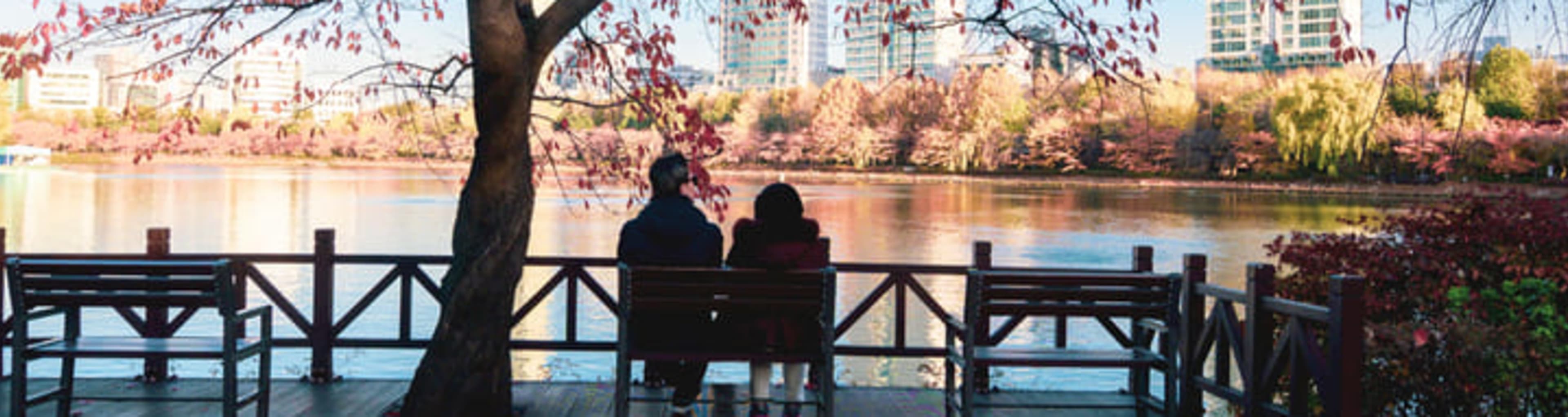 Couple enjoying the view from a bench at Seokchon Lake Park in Seoul.