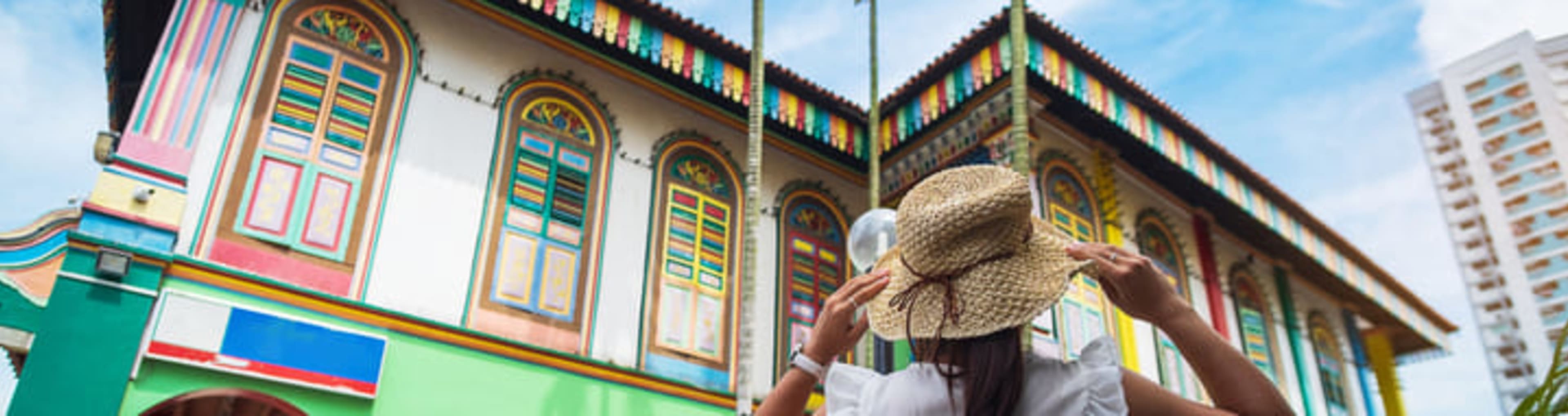 Woman exploring colorful buildings in Singapore's Little India neighborhood