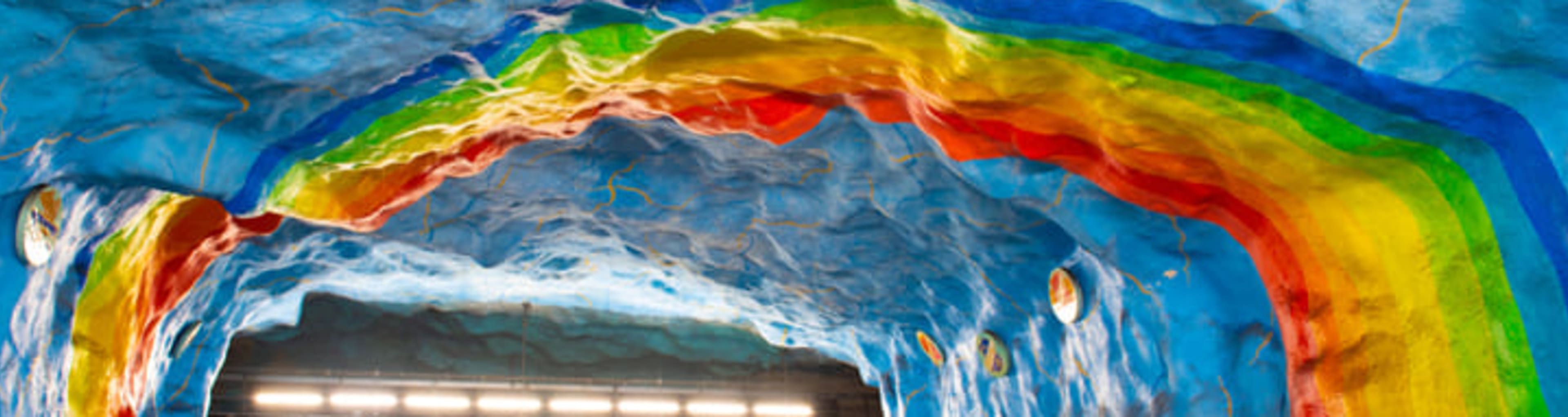 Art depicting rainbows and blue skies on the platform of Stockholm's Stadion metro station