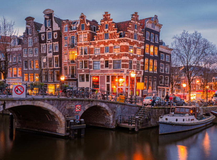 Amsterdam canal houses and bridge reflected in a still canal