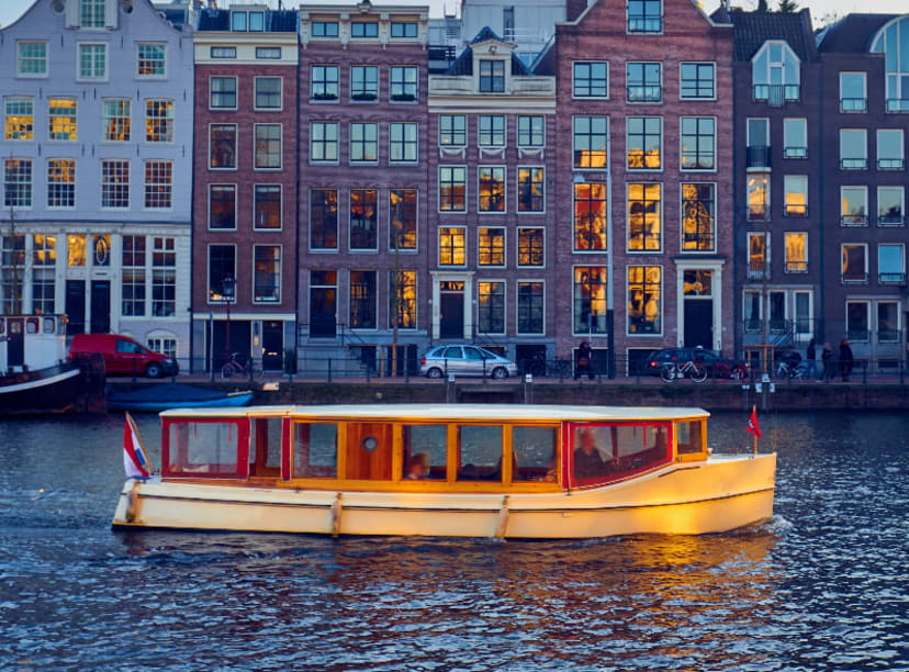 Canal boat passing by iconic Amsterdam canal houses