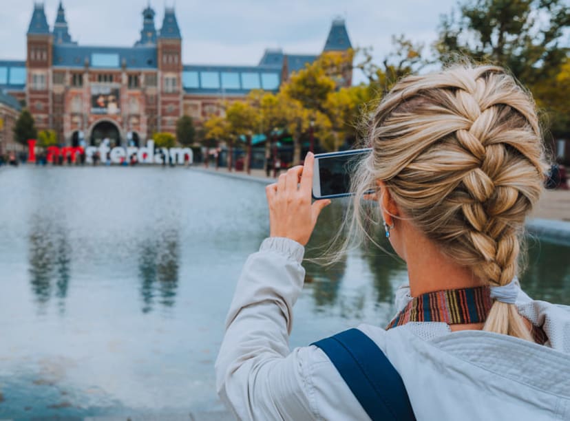 Woman photographing the Rijksmuseum in Amsterdam