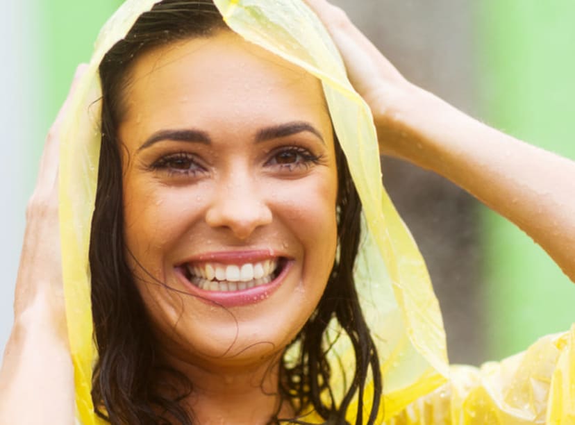 Woman wearing a rain poncho during a downpour.