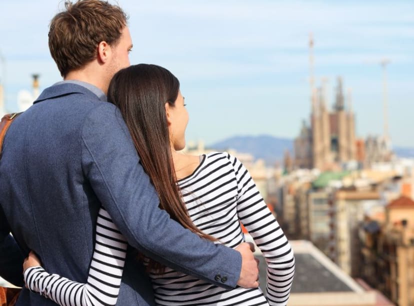 Close up rear view of couple looking out over Barcelona and Sagrada Familia