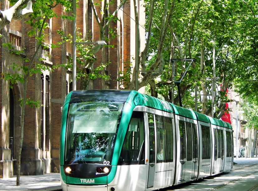 A modern tram driving through the streets of Barcelona