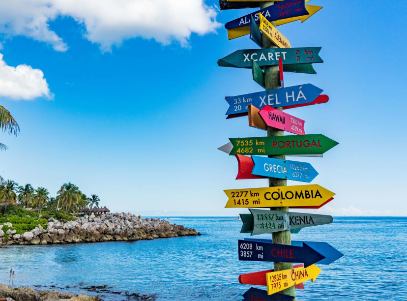 A colorful handmade signpost pointing to the many things to do in Cancun