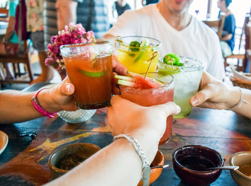 Friends share cocktails in a Cancun bar