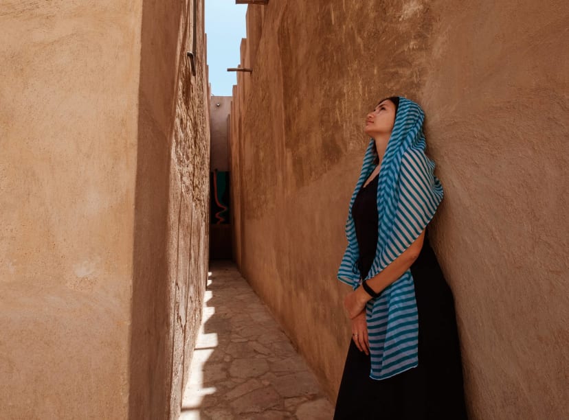 A woman seeks the shade of an alleyway in Old Dubai