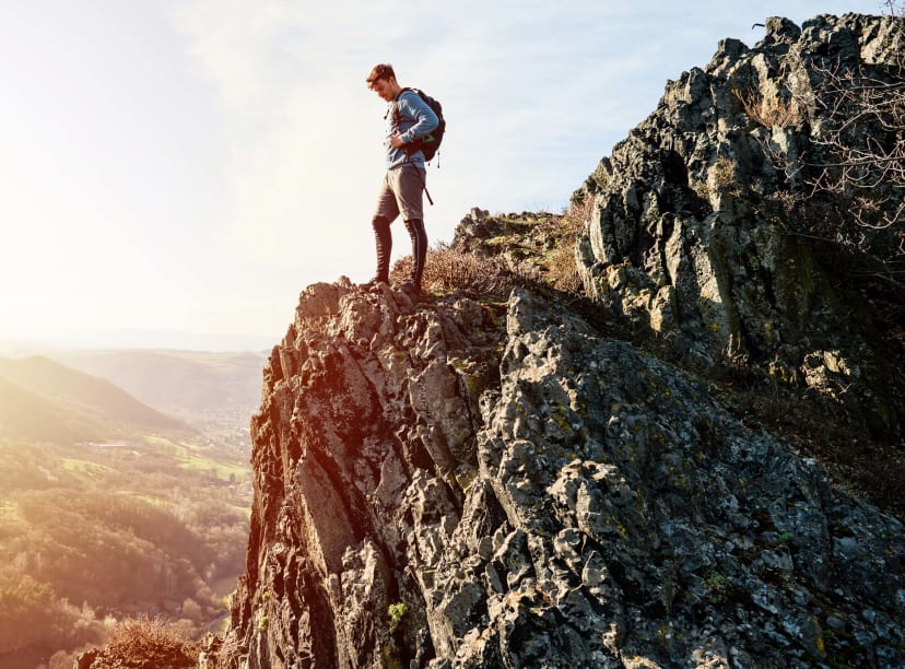 A hiker looks out from a cliffside viewpoint