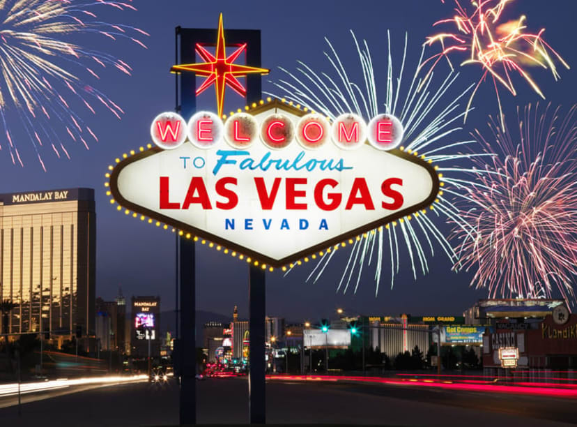 Fireworks exploding behind the neon-lit 'Welcome to Fabulous Las Vegas' road sign