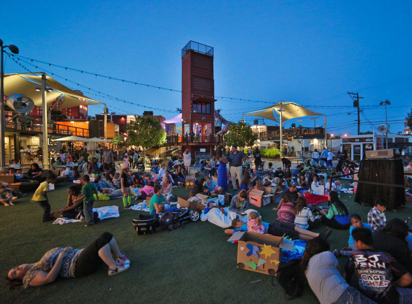 Outdoor space at Container Park featuring a grassy area, string lights, outdoor entertainment, and more.