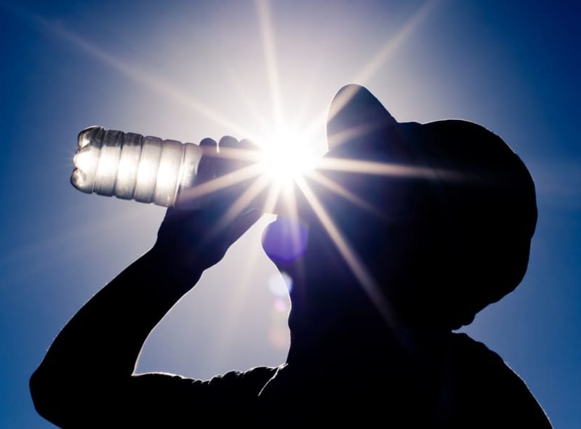 Silhouette of man drinking water on a hot day