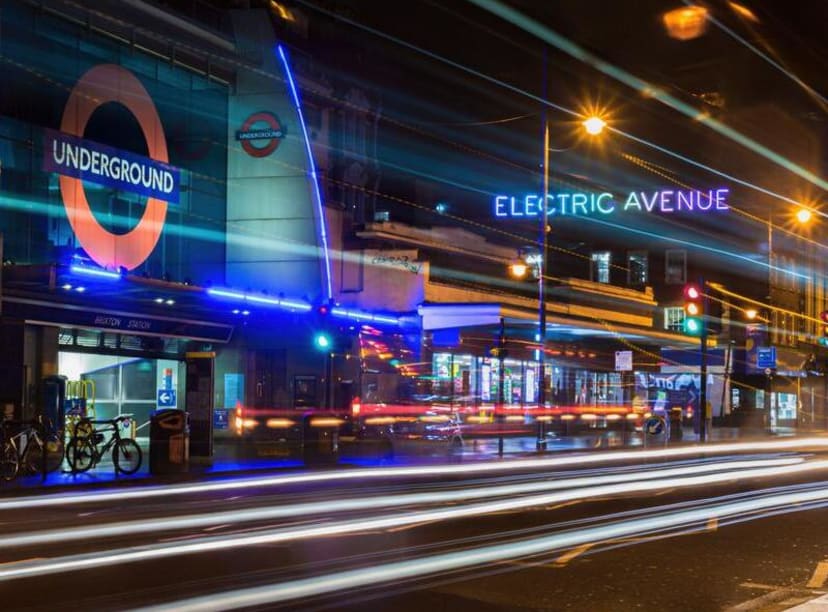 Brixton underground station and Electric Avenue at night.