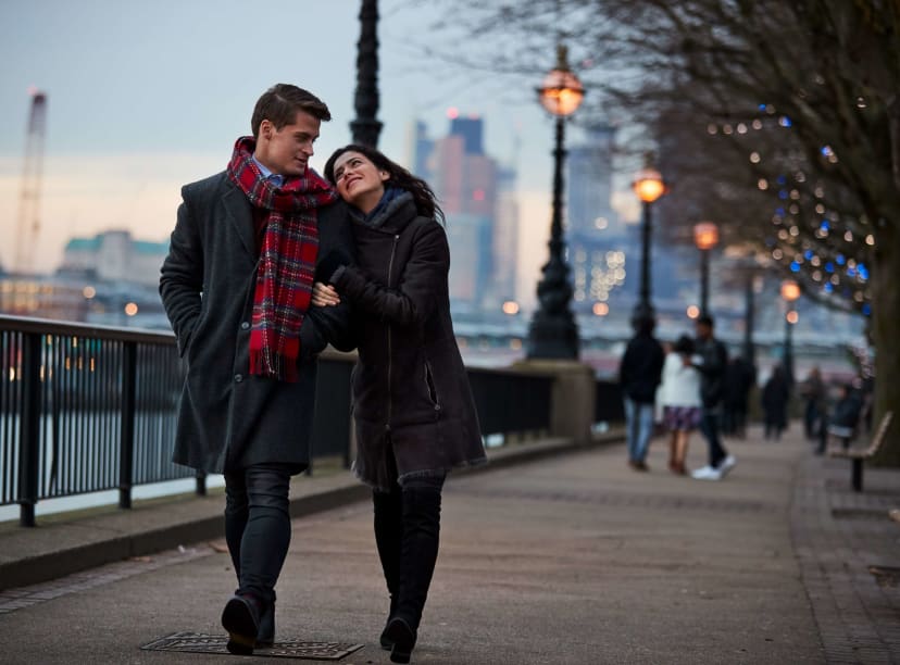 A couple enjoying a romantic walk along the River Thames in central London