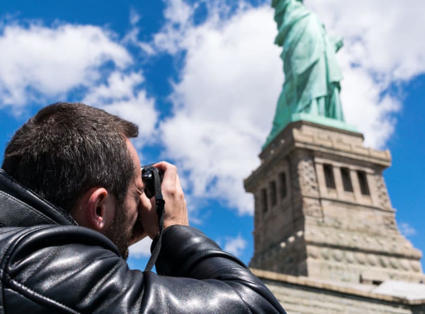 Man photographing the Statue of Liberty