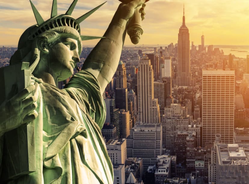 Statue of Liberty in close-up with the New York skyline beyond.