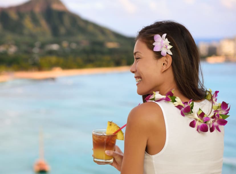Woman wearing a lei and drinking a Mai Tai in Hawaii