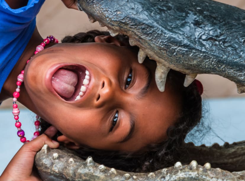 Niña jugando con escultura de caiman en Orlando