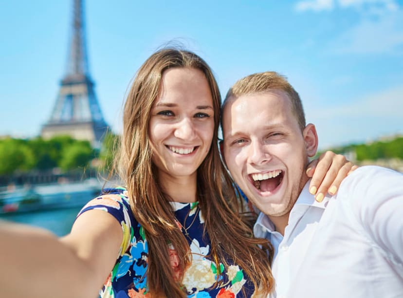 Young couple taking a selfie in front of the Eiffel Tower