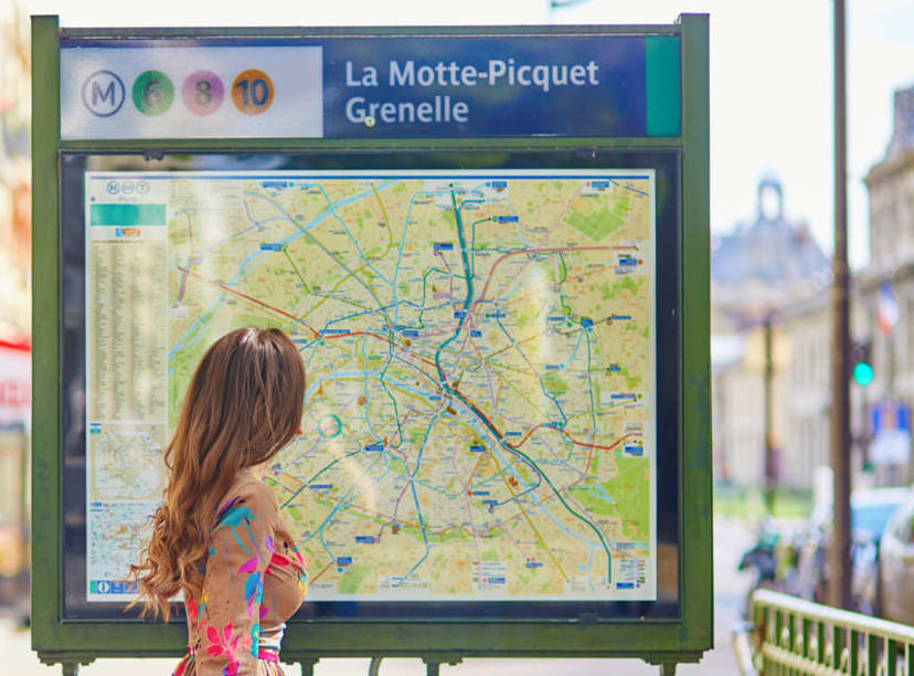 Woman looking at a Paris Métro map outside the station