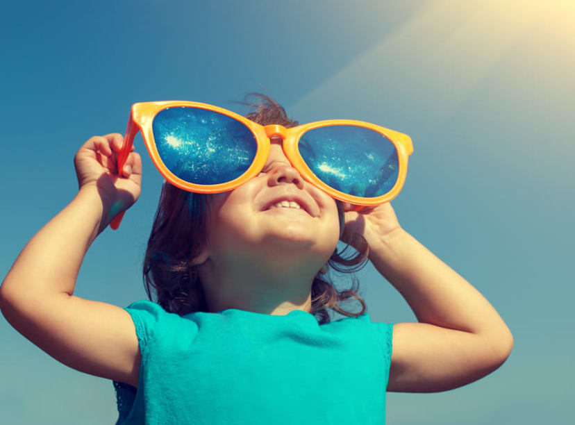 Kid wearing oversized sunglasses on a sunny day