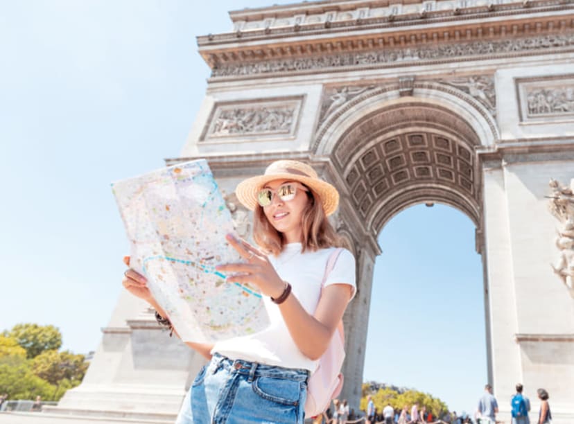 A woman consults her map in front of the Arc de Triomphe in Paris
