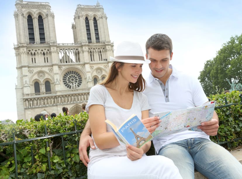 A couple sit in front of Notre-Dame Cathedral