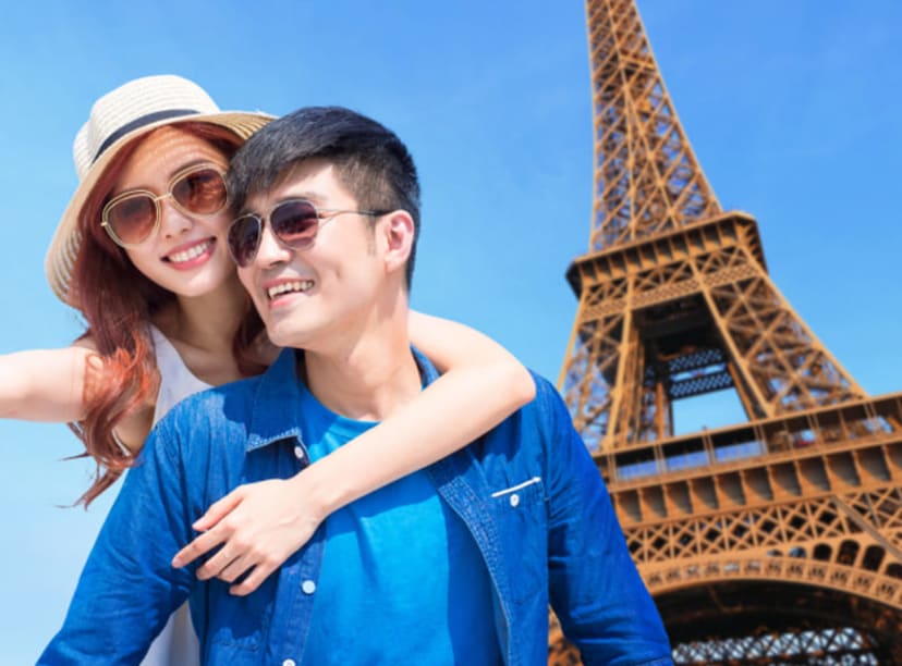 A young couple in front of the Eiffel Tower